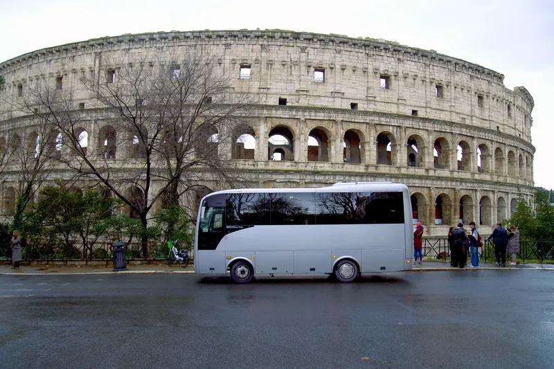 Bus di medie dimensioni davanti al Colosseo a Roma