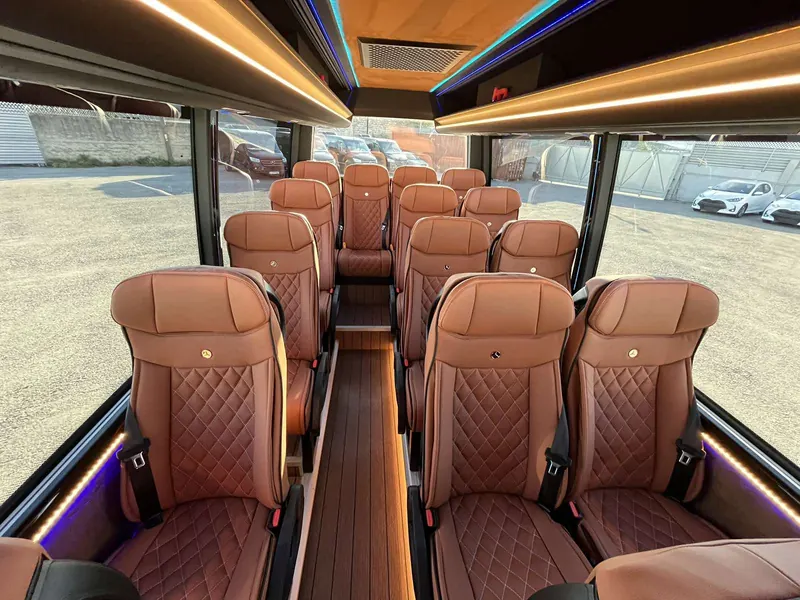 Interno di un minibus con sedili in pelle trapuntata e luci d'ambiente